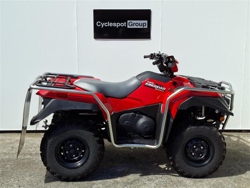 Load image into Gallery viewer, A red and black 2026 Suzuki KingQuad LT-A500 four-wheeler ATV with a silver front bumper and rear rack, parked in front of a white wall with a 'Cyclespot Group' sign.