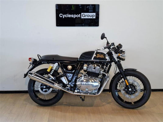 A 2026 Royal Enfield Continental GT Classic Cruiser motorcycle in black and chrome, parked indoors on a light wood floor against a white wall with a 'Cyclespot Group' sign above it.