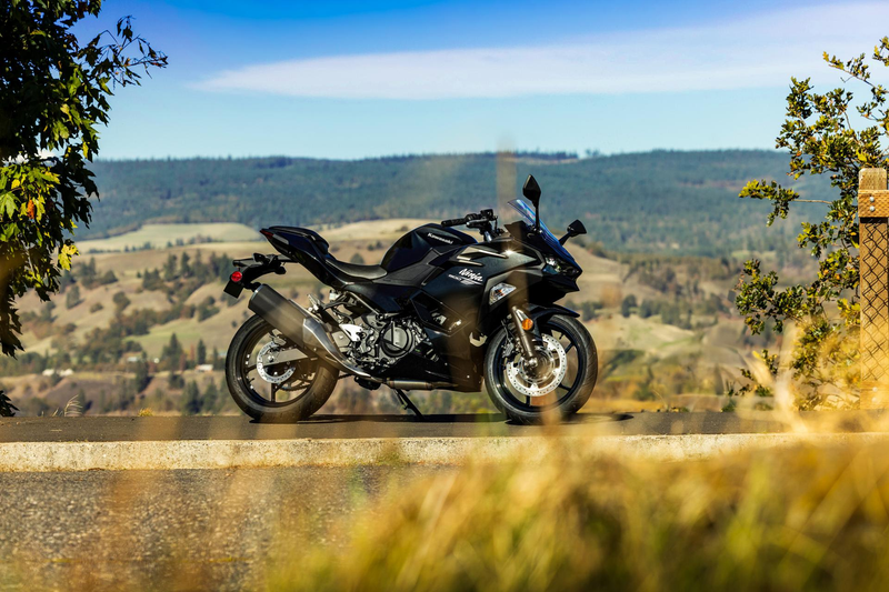 Load image into Gallery viewer, Black Kawasaki Ninja 500 motorcycle on a scenic road with mountains in the background
