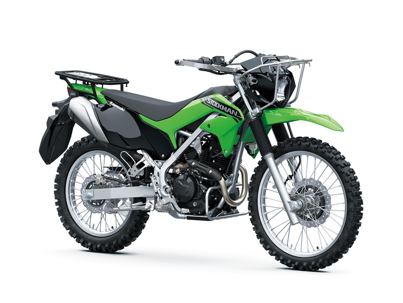 Load image into Gallery viewer, A green and black Kawasaki dirt bike with silver metal components, knobby off-road tires, and a rear luggage rack, photographed on a seamless white background.
